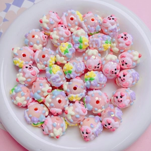 Macro shot of pink acrylic pig beads with star and heart patterns for DIY jewelry making