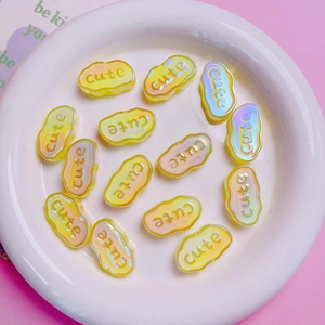 Macro shot of colorful gradient acrylic cloud beads with engraved Cute text for DIY crafts