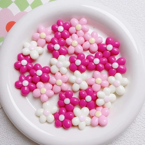 Macro view of 20mm acrylic flower beads in pink and white for DIY craft making