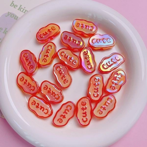 Macro detail of iridescent orange acrylic beads with raised cute letters for DIY jewelry