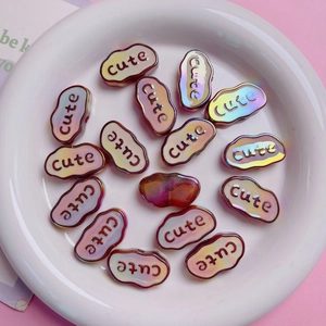 Macro view of cloud-shaped iridescent acrylic beads with cute text for DIY crafts