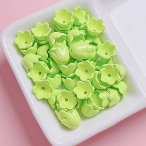 Macro shot of green acrylic lily-of-the-valley flower beads for DIY jewelry making