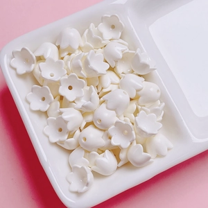 Detailed view of cream-colored lily of the valley acrylic beads for DIY jewelry making