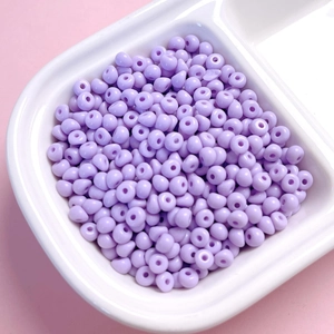 Gros plan de perles acryliques de 4mm lavande dans un plateau pour bijoux DIY