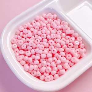 Gros plan de perles gouttes en acrylique rose de 4mm pour la création de bijoux