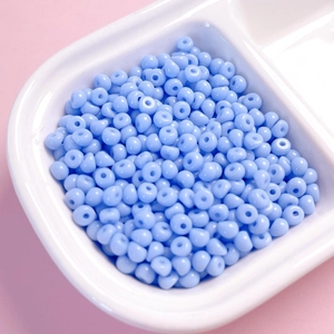 Détail de perles gouttes en acrylique bleu ciel de 4 mm dans un plateau blanc