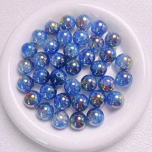 Cuentas degradadas UV 16mm azul con efecto aurora sobre bandeja de cerámica