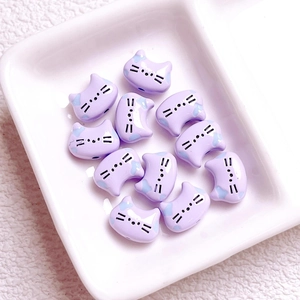 Vista macro di perline in ceramica viola a testa di gatto per gioielli fai-da-te su vassoio