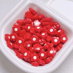 Macro detail of red acrylic flower beads for DIY phone chains and jewelry making