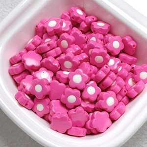 Macro view of rose pink acrylic flower beads with white center for DIY jewelry making