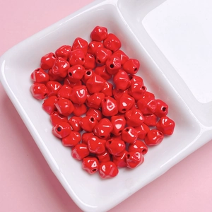 Vista detallada de cuentas de carambola rojas brillantes con agujeros para joyería DIY