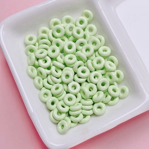 Mint green donut beads in a ceramic tray for DIY jewelry and phone chain making