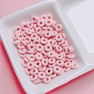 Macro shot of colorful light pink donut-shaped alloy beads for DIY jewelry making