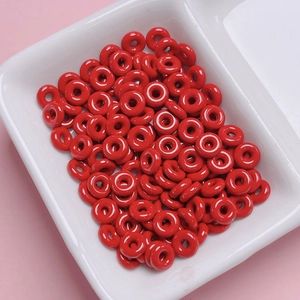 Close-up of vibrant red doughnut-shaped alloy beads for DIY jewelry and phone chains