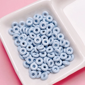 Macro view of light blue glazed donut-shaped beads for DIY jewelry making accessories