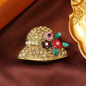 Detailed close-up of a vintage hat-shaped brooch with colorful rhinestone flowers