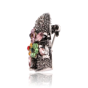 Macro detail of a vintage style hat brooch with colorful rhinestones and floral alloy pattern