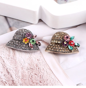 Close-up of vintage mini hat brooches with pavé crystal and colorful floral gems