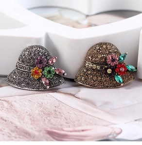 Macro detail showing vintage hat brooches with multi-color rhinestones and fine metalwork
