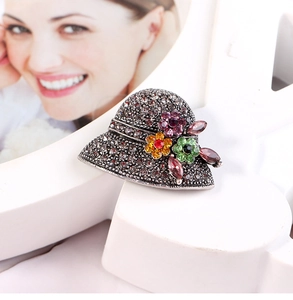 Macro shot of vintage hat brooch featuring grey rhinestones and colorful crystal flowers