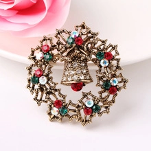 Detailed macro view of vintage Christmas wreath brooch with colorful rhinestones and bell