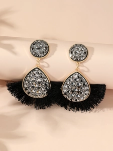 Detailed close-up of crystal fan earrings with elegant black fiber tassels and gold frame