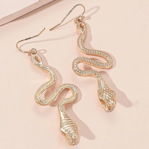 Gothic punk gold snake earrings with detailed scale texture on peach background