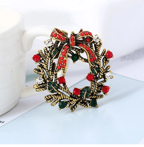 Close-up of vintage Christmas wreath brooch with colorful rhinestones and a red bow