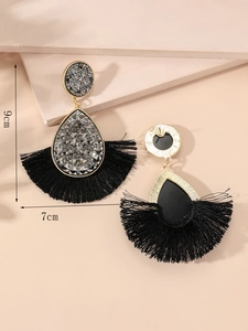 Detail view of crystal water-drop studs with black fan-shaped tassels and size labels