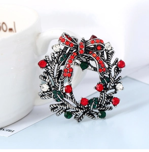 Detailed view of Christmas wreath brooch with red bow and multi-colored rhinestones