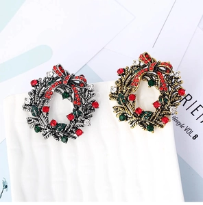 Detailed view of festive Christmas wreath brooches with red and green rhinestones