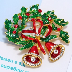 Detailed macro view of enamel Christmas bell brooch with wreath and rhinestone accents