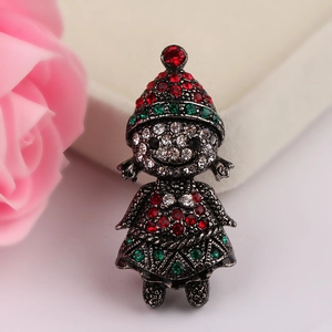 Macro shot of retro silver Christmas girl brooch with red and green rhinestones