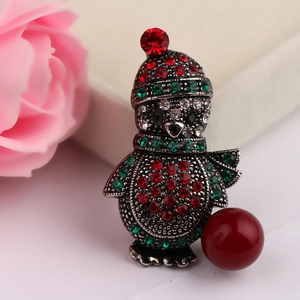 Macro shot of a Christmas penguin brooch with colorful rhinestones and a red faux pearl