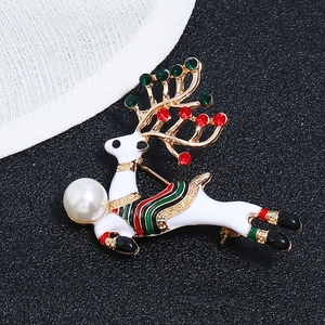 Détail d'une broche de renne de Noël avec émail blanc, perle et strass colorés brillants
