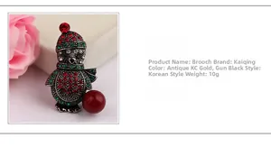 Detail of Christmas penguin brooch featuring red and green rhinestones on vintage gold base