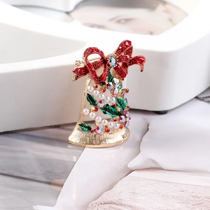 Detail of Christmas bell brooch with red rhinestone bow, pearls, and green leaf accents