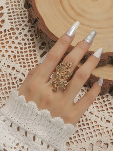 Detail eines Vintage-Boho-Goldrings mit aufwendigen Schnitzereien und funkelnden Kristallen