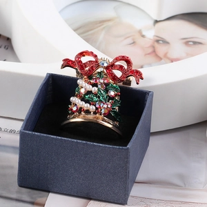 Detail of Christmas bell brooch with red bow and pearls in a blue gift box