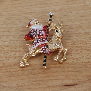 Detail of Christmas Santa Claus brooch with reindeer, red enamel and sparkling rhinestones