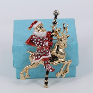 Detail of Santa Claus and reindeer brooch with crystals and colored enamel on jewelry box
