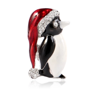 Détail de la broche pingouin avec bonnet en émail rouge et strass brillants pour Noël