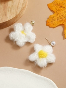 Detailed macro view of handmade crochet daisy earrings with white pearls and S925 silver pins