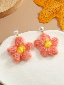Close-up of handmade crochet flower earrings with pink petals and white pearl studs
