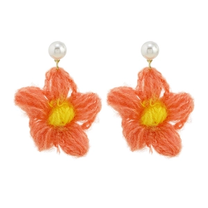 Handmade crochet flower earrings with orange petals and pearl studs on white background