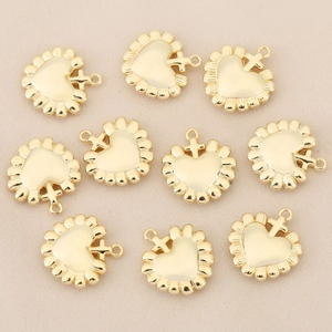 Detail shot of 18k gold plated heart pendants with cross design for DIY jewelry making