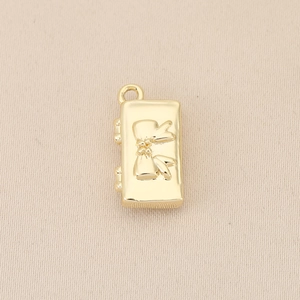Close-up of a 18k gold plated rectangular pendant featuring a 3D bowknot design and ring