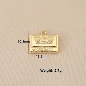 Detalle macro del colgante de casete retro bañado en oro 18k con circonitas