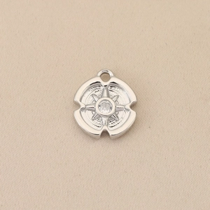 Macro shot of silver eight-pointed star pendant with cubic zirconia on beige fabric
