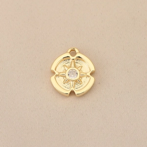 Close-up of gold plated 18k starburst pendant with sparkling center zircon crystal